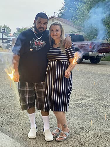 Couple holding sparklers on a street