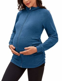 Pregnant woman wearing a blue zip-up hoodie