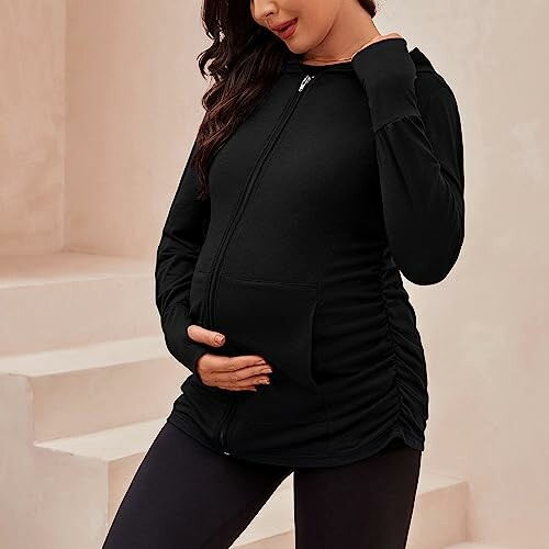 Pregnant woman wearing a black hoodie.