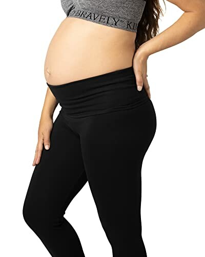 Pregnant woman wearing black maternity leggings and a grey top.