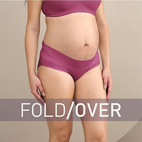 Woman wearing pink maternity underwear with fold-over waistband.