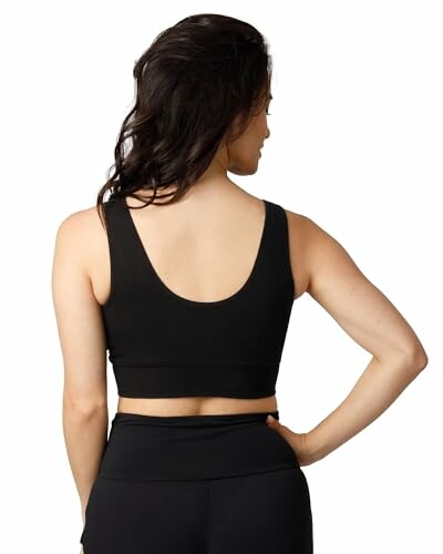 Woman wearing a black sports bra viewed from the back.