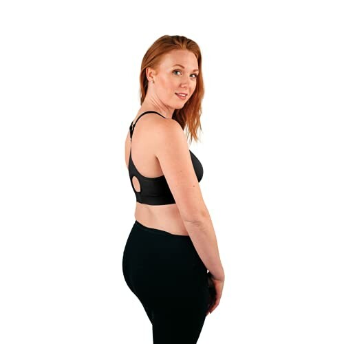 Woman modeling black sports bra and leggings.