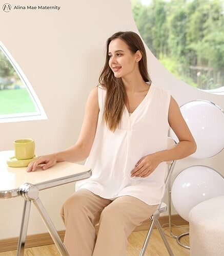 Woman in white maternity top sitting at a table