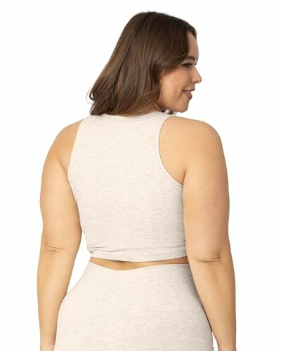 Woman wearing a light sleeveless top, viewed from the back.